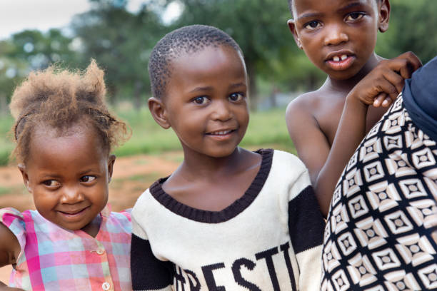 istock village african kids, playing in the yard , three siblings 1973069353
