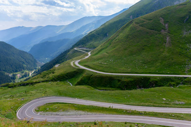 istock Winding road among green mountains on summer day 1973069640