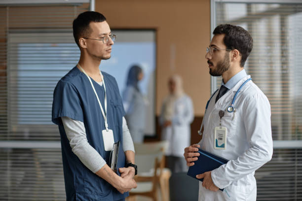 istock Male Medics Talking in Hall 1973071975