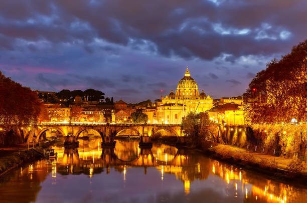 Beautiful vibrant night image of St. Peter's Basilica, Ponte Sant Angelo and Tiber River at dusk in Rome, Italy. stock photo