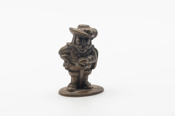 Small bronze figurine of a musketeer with a hat on white background