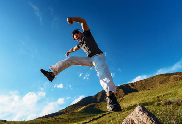 istock Handsome athletic young man jumping on mountains background 1973123667