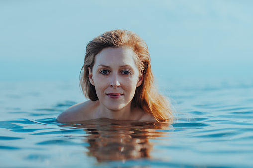 Portrait of beautiful young blond woman in the sea