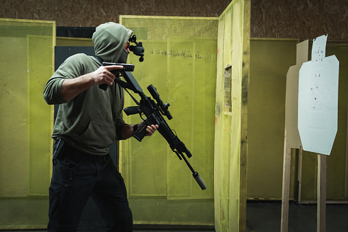 A man engages in tactical rifle and pistol shooting at a shooting range. High quality photo