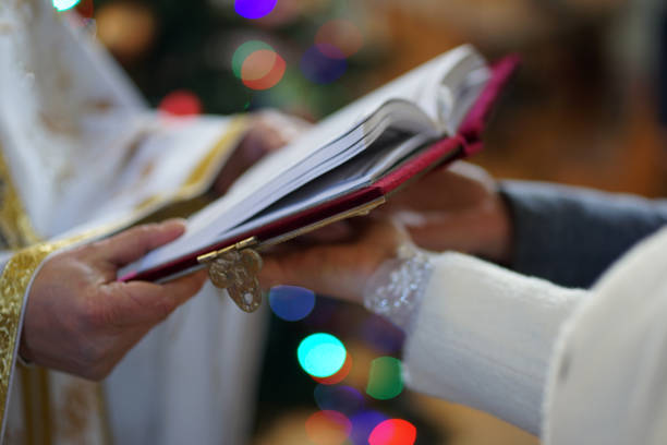 The newlyweds hold the Gospel, which is read by the priest during the wedding ceremony. The photo was taken in soft focus. The newlyweds hold the Gospel, which is read by the priest during the wedding ceremony. The photo was taken in soft focus. god is love stock pictures, royalty-free photos & images
