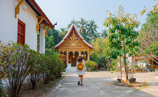 Woman exploring buddhist temple in Laos  during vacation in Southeast Asia