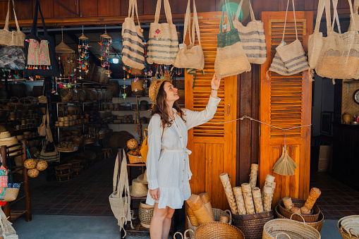 Cheerful shopping woven souvenirs during her trip to Asia