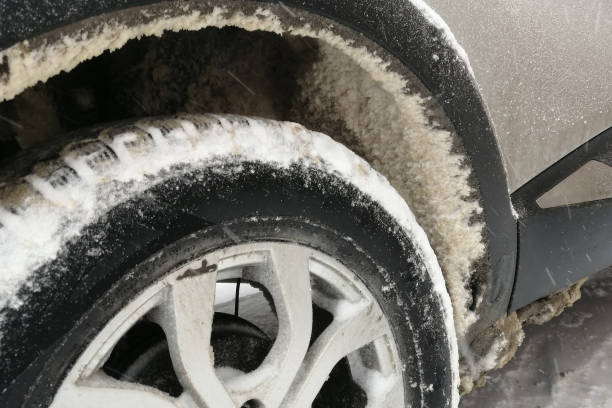 neve presa ao arco da roda de um carro. close-up - tampa da jante - fotografias e filmes do acervo