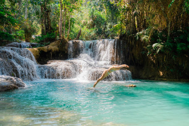 Young Caucasian woman near the  Kuang si waterfall in tropical forest in Southeast Asia, Laos