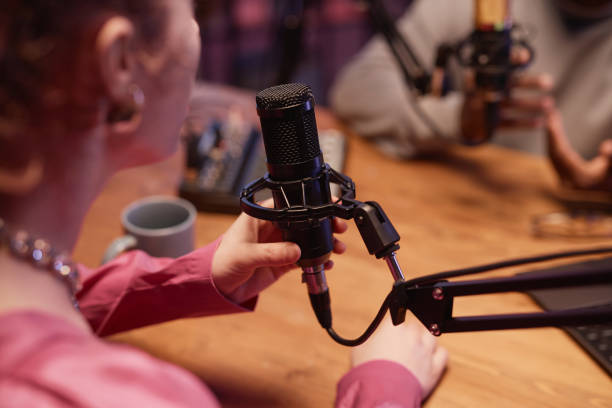 istock Woman Holding Studio Microphone in Podcast Room 1973173799