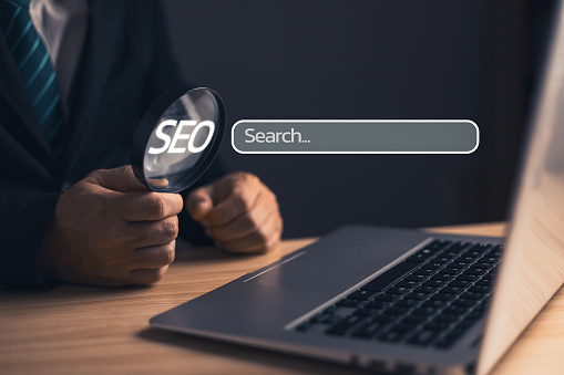 Businessman holding magnifying glass. Searching Browsing Internet Data Information with blank search bar. Search Engine Optimization SEO Networking Concept.