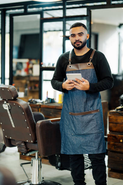 istock Barber standing in a barber shop with a digital tablet 1973193015