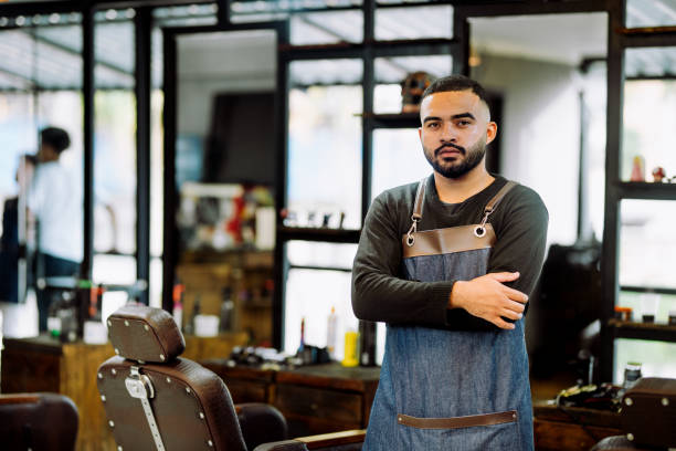 istock Barber standing with his arms crossed in a barber shop 1973193018
