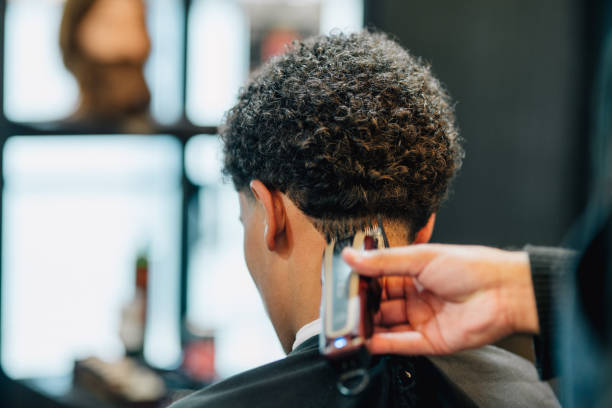 Young African American Man Receiving Fade Haircut from Mexican Barber in an Old Fashioned Barbershop with Electric Clippers
