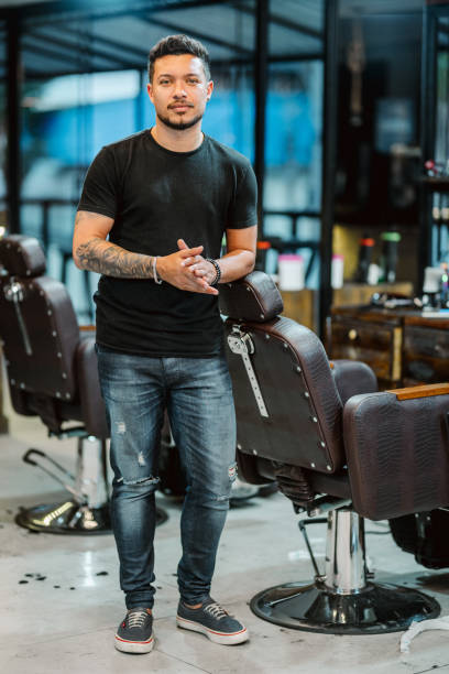 istock Barber leaning on a chair while working in a barber shop 1973194674