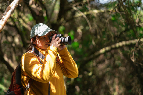 istock a woman in yellow jacket and grey hat taking picture with camera 1973197817