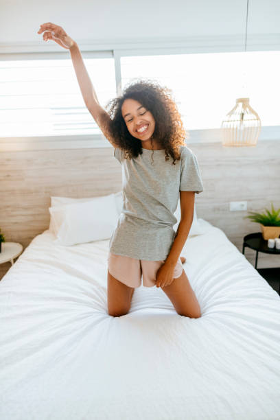 istock Funny woman standing on bed 1973198328
