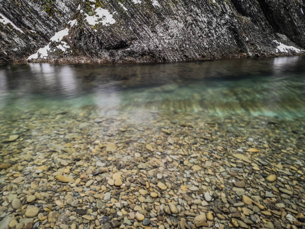 Mountain river near a rock in a winter forest
