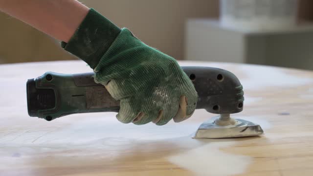 Grinding the surface of an old table.