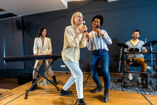 istock Business people making team training exercise during team building seminar singing karaoke. 1973256357