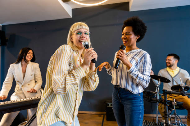 istock Business people making team training exercise during team building seminar singing karaoke. 1973256863