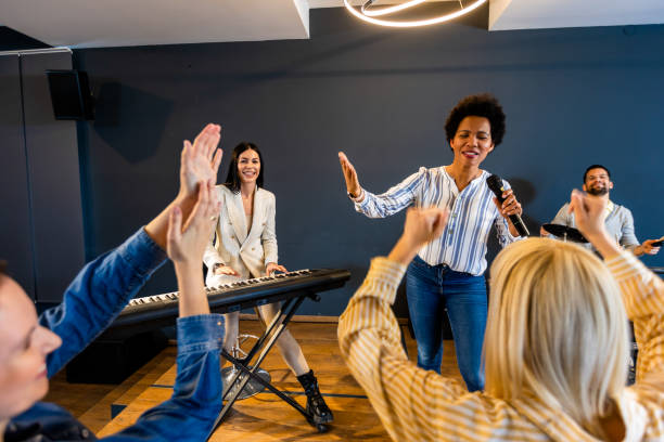 istock Business people making team training exercise during team building seminar singing karaoke. 1973257387