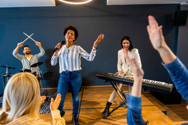 istock Business people making team training exercise during team building seminar singing karaoke. 1973257898