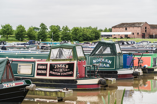 Nantwich, Cheshire, England, June 6th 2023. Marina with traditional parked narrowboats, transport, tourism and editorial travel illustration.
