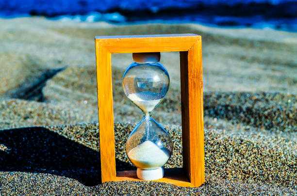 istock Hourglass Clock on the Sand Beach 1973262239