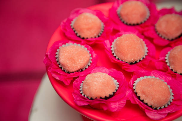 Assorted cupcakes with white icing displayed on a pink cake plate