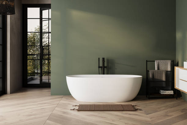 istock Modern minimalist bathroom interior, bathtub and bathroom cabinet, white sink, interior plants, bathroom accessories, parquet floor, green wall. 1973272822
