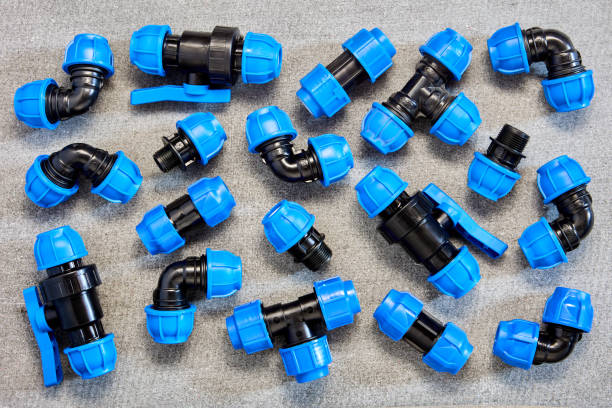 Polypropylene compression clamping fittings for pipeline system made of HDPE pipes laid out on gray slate sheet. Set of pipe compression adapter connectors for HDPE pipes is laid out on sheet of slate. coupling stock pictures, royalty-free photos & images