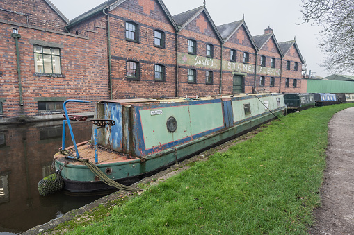 Stone, Staffordshire, England, December 1st 2022. Joule's Crown Wharf Brewery against narrowboats. in the foreground.