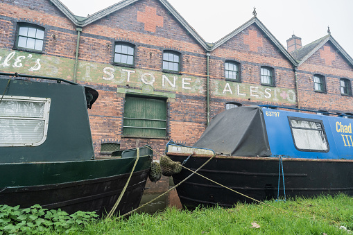 Stone, Staffordshire, England, December 1st 2022. Joule's Crown Wharf Brewery against narrowboats. in the foreground.