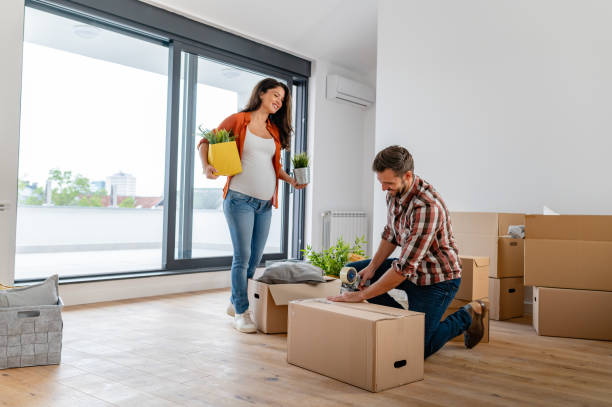 istock Young couple just moved into new empty apartment unpacking and cleaning 1973349583