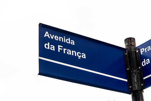 Street view , yellow arrow symbol of the Camino de Santiago, Camino portugués in  old town  Valença do Minho, Minho, Portugal. Stores with retail display in the background.