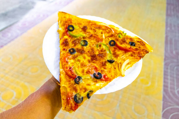Pizza on white plate in the hand on Koh Phi Phi Don island in Ao Nang Amphoe Mueang Krabi Thailand in Southeast Asia.