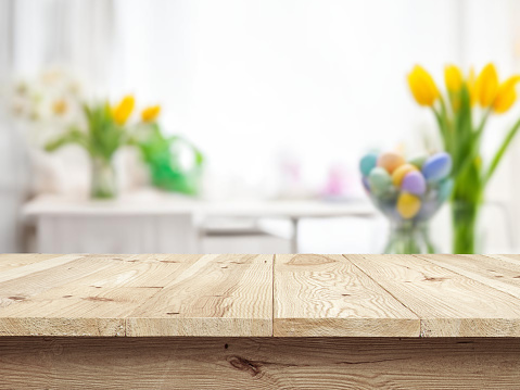 Table or surface on background of flowers and painted eggs. Easter concept.