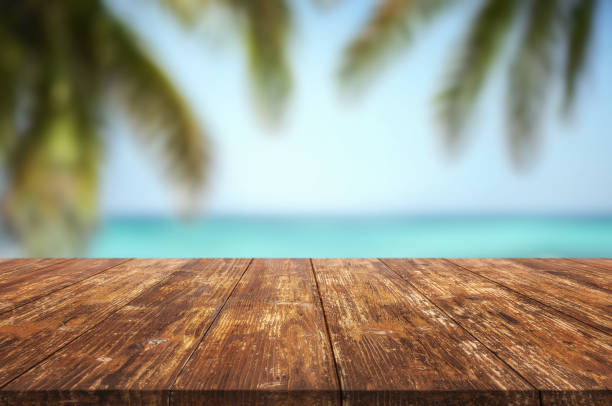 istock Table or surface with tropical swimming pool or beach in the background 1973395474