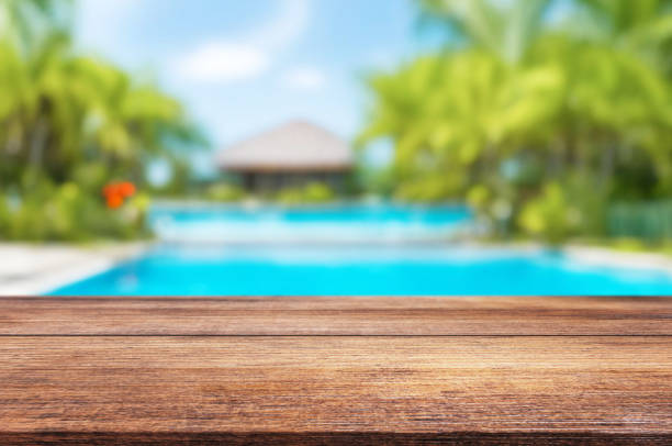 istock Table or surface with tropical swimming pool or beach in the background 1973401183