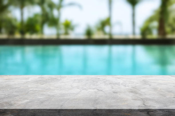istock Table or surface with tropical swimming pool or beach in the background 1973403874