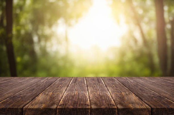 istock Wooden table on window background with garden and trees 1973410806