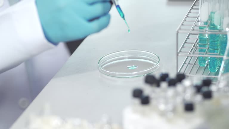 Close Up Of Scientist's Hand Using Droplet Fill Chemical Substance On Petri Dish In A Laboratory