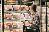 Man buying meat at grocery store