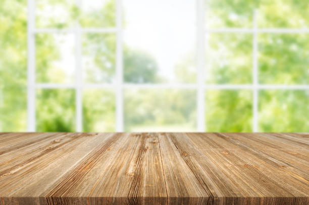 istock Wooden table on window background with garden and trees 1973414941