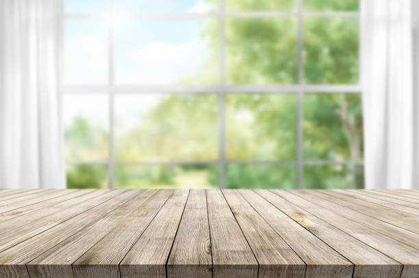 istock Wooden table on window background with garden and trees 1973417121