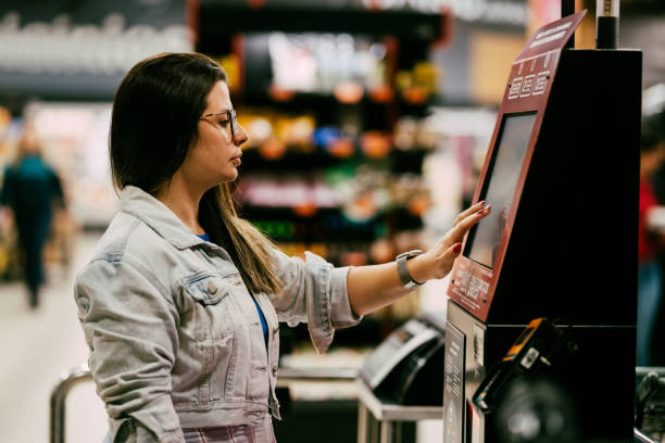 istock Woman customer using digital touch screen display for payment while shopping in department store 1973418678