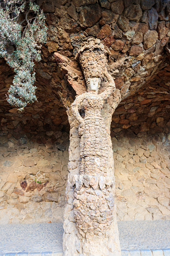 Stone sculpture of a woman on a column in park Guell in Barcelona, Spain