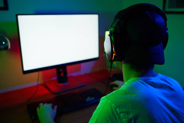 istock Young man wearing headset and play computer video games online 1973443110