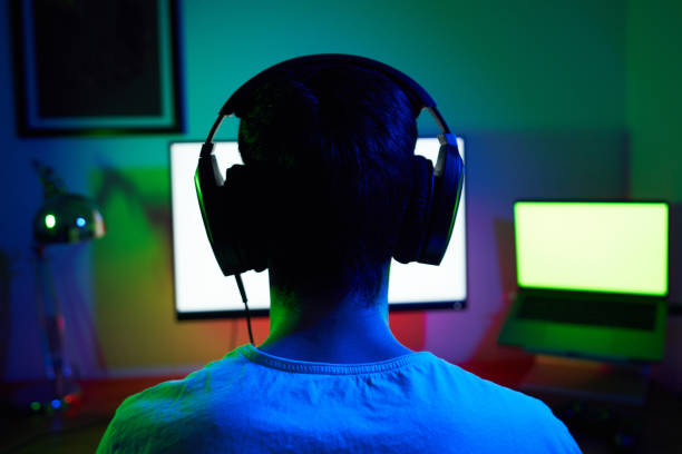 istock Young man wearing headset and play computer video games online 1973443121